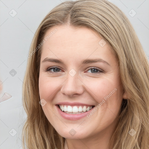 Joyful white young-adult female with long  brown hair and blue eyes