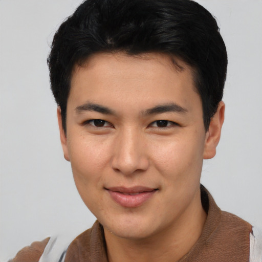 Joyful asian young-adult male with short  brown hair and brown eyes