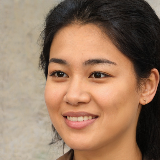 Joyful asian young-adult female with long  brown hair and brown eyes