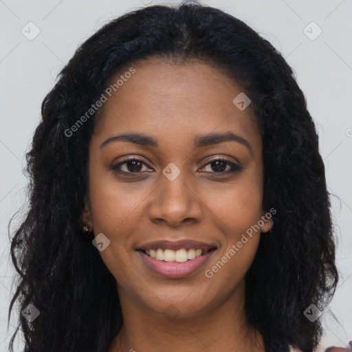 Joyful black young-adult female with long  black hair and brown eyes