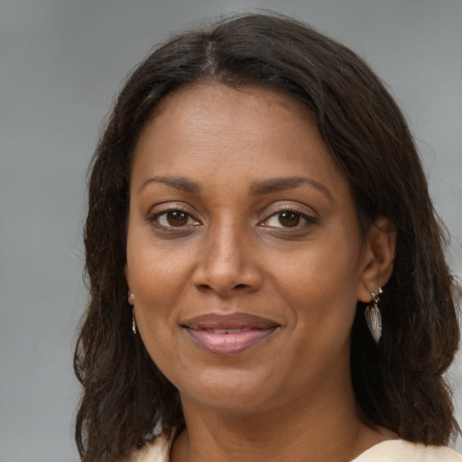 Joyful black adult female with medium  brown hair and brown eyes