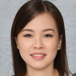 Joyful asian young-adult female with long  brown hair and brown eyes