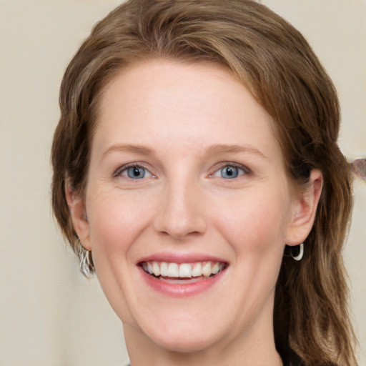 Joyful white young-adult female with long  brown hair and blue eyes