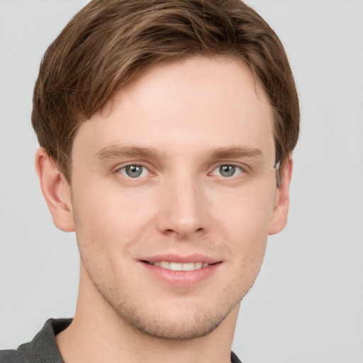 Joyful white young-adult male with short  brown hair and grey eyes