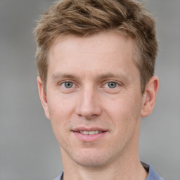 Joyful white young-adult male with short  brown hair and grey eyes