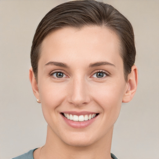 Joyful white young-adult female with short  brown hair and grey eyes