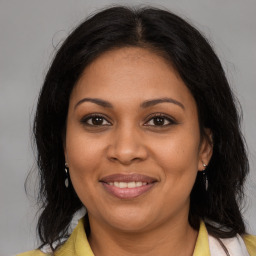 Joyful black adult female with medium  brown hair and brown eyes