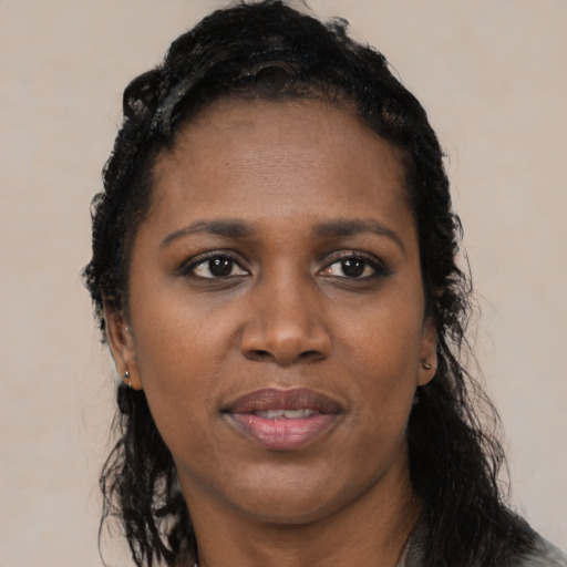Joyful black young-adult female with long  black hair and brown eyes