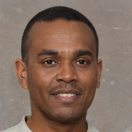 Joyful black young-adult male with short  brown hair and brown eyes