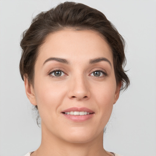 Joyful white young-adult female with short  brown hair and grey eyes