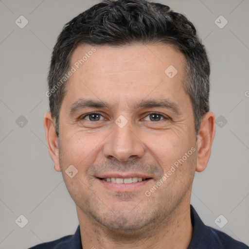 Joyful white adult male with short  black hair and brown eyes