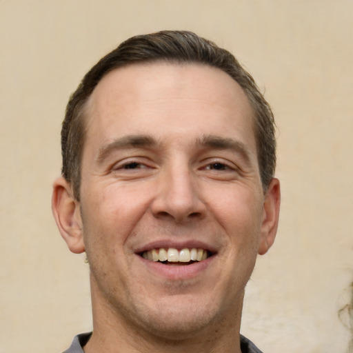 Joyful white adult male with short  brown hair and brown eyes