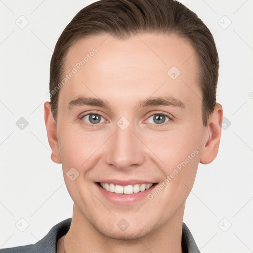 Joyful white young-adult male with short  brown hair and grey eyes