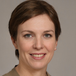 Joyful white young-adult female with medium  brown hair and grey eyes