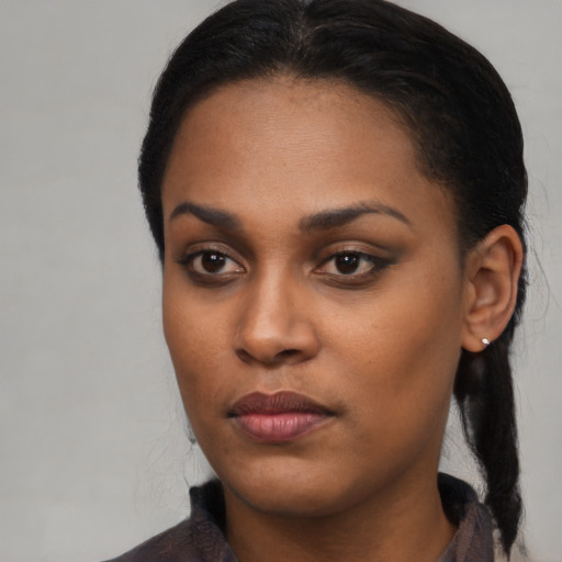 Joyful black young-adult female with long  black hair and brown eyes