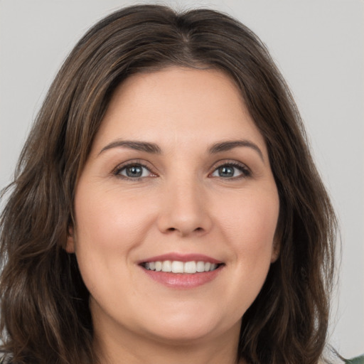 Joyful white young-adult female with long  brown hair and brown eyes