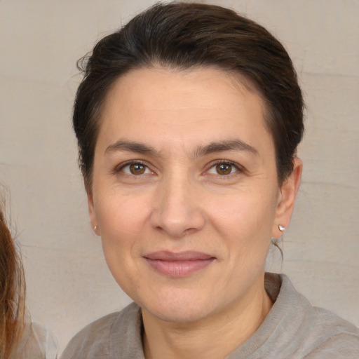 Joyful white adult female with medium  brown hair and brown eyes