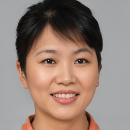 Joyful asian young-adult female with short  brown hair and brown eyes