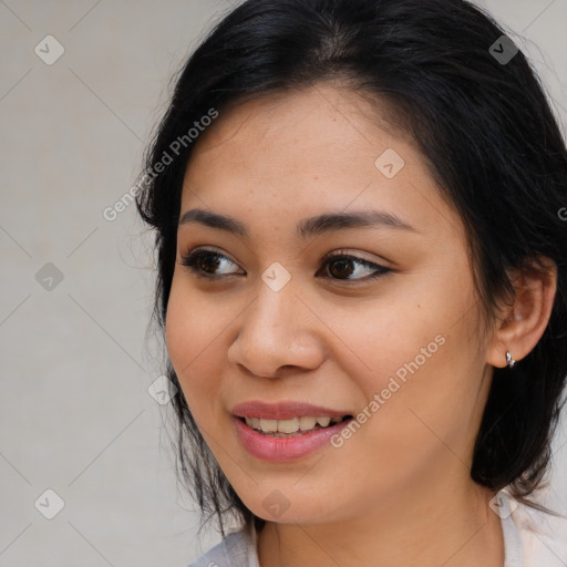 Joyful latino young-adult female with medium  brown hair and brown eyes