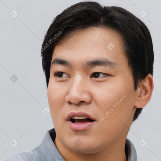 Joyful asian young-adult male with short  brown hair and brown eyes