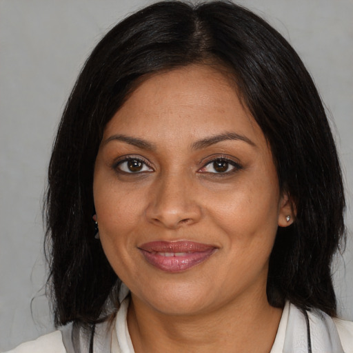 Joyful black adult female with medium  brown hair and brown eyes