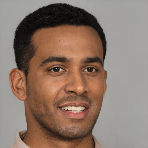 Joyful black young-adult male with short  brown hair and brown eyes