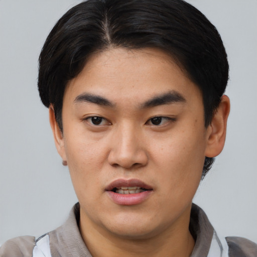Joyful asian young-adult male with short  black hair and brown eyes
