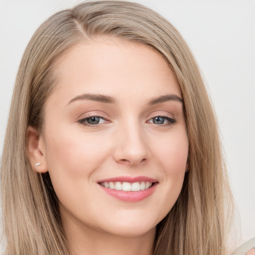 Joyful white young-adult female with long  brown hair and grey eyes