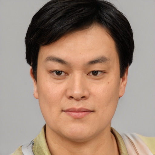 Joyful asian young-adult male with short  black hair and brown eyes