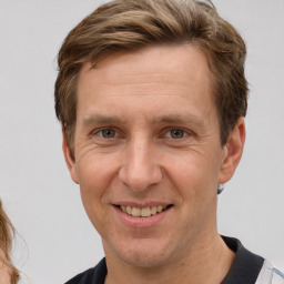 Joyful white adult male with short  brown hair and grey eyes