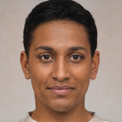Joyful black young-adult male with short  black hair and brown eyes