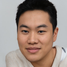 Joyful asian young-adult male with short  black hair and brown eyes