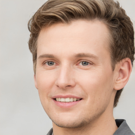 Joyful white young-adult male with short  brown hair and grey eyes