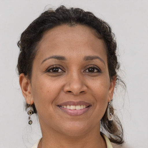 Joyful latino adult female with medium  brown hair and brown eyes