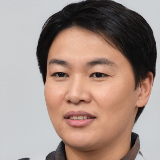 Joyful asian young-adult female with short  brown hair and brown eyes