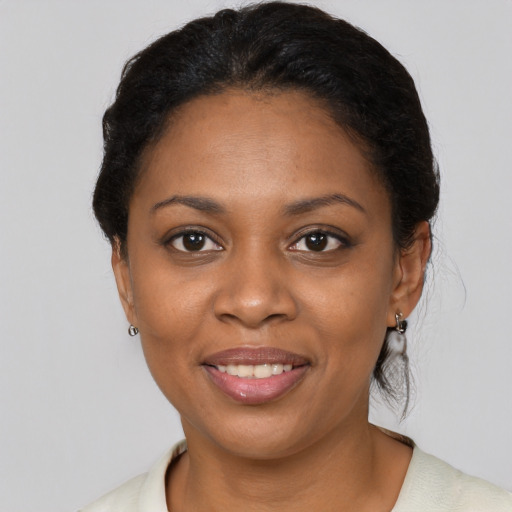 Joyful black young-adult female with short  black hair and brown eyes
