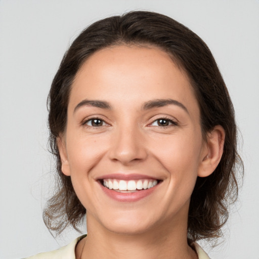 Joyful white young-adult female with medium  brown hair and brown eyes