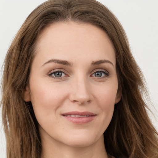 Joyful white young-adult female with long  brown hair and green eyes