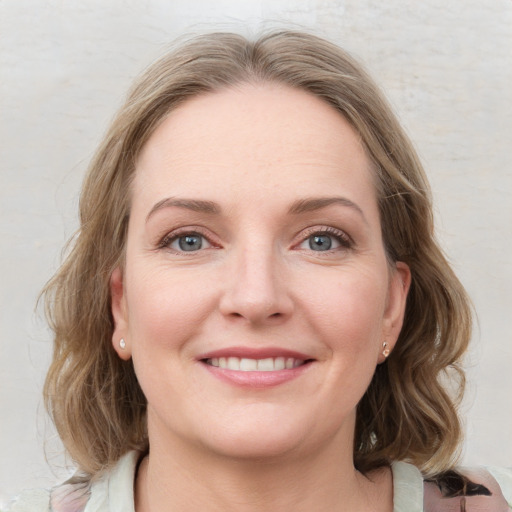 Joyful white young-adult female with medium  brown hair and blue eyes