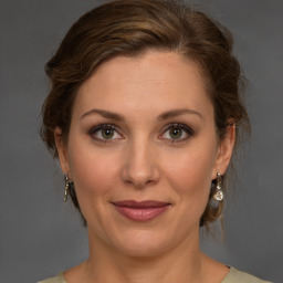 Joyful white young-adult female with medium  brown hair and green eyes