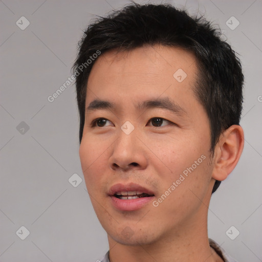 Joyful asian young-adult male with short  black hair and brown eyes