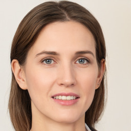 Joyful white young-adult female with long  brown hair and grey eyes