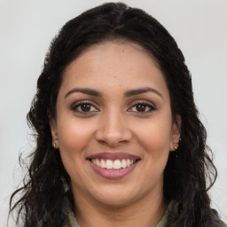 Joyful latino young-adult female with long  brown hair and brown eyes