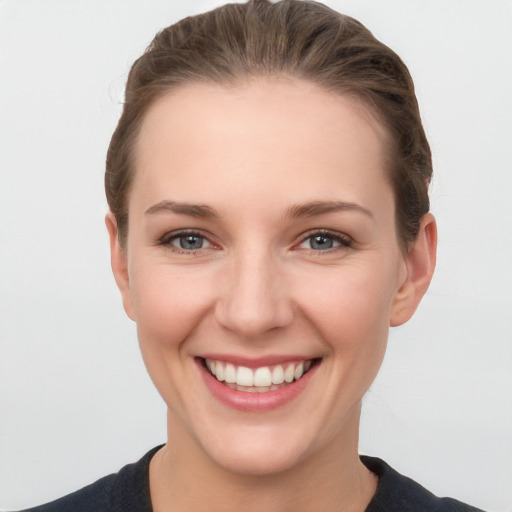 Joyful white young-adult female with short  brown hair and grey eyes