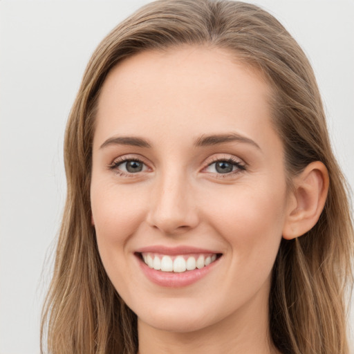 Joyful white young-adult female with long  brown hair and blue eyes