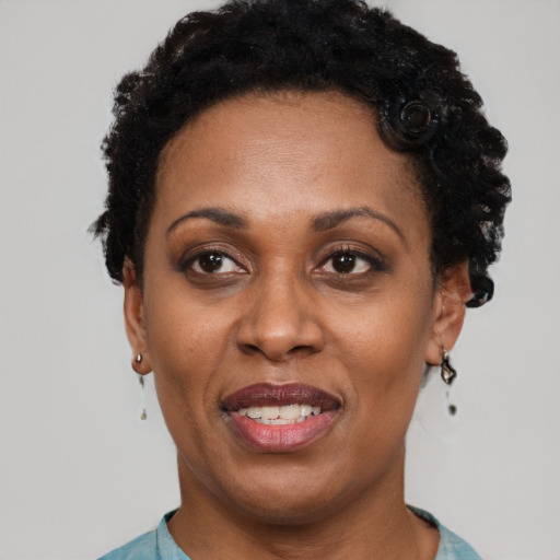 Joyful black adult female with short  black hair and brown eyes