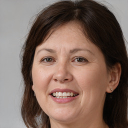 Joyful white adult female with medium  brown hair and brown eyes