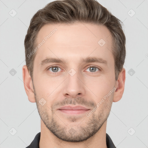 Joyful white young-adult male with short  brown hair and grey eyes