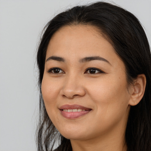 Joyful asian young-adult female with long  brown hair and brown eyes