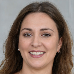 Joyful white young-adult female with long  brown hair and grey eyes